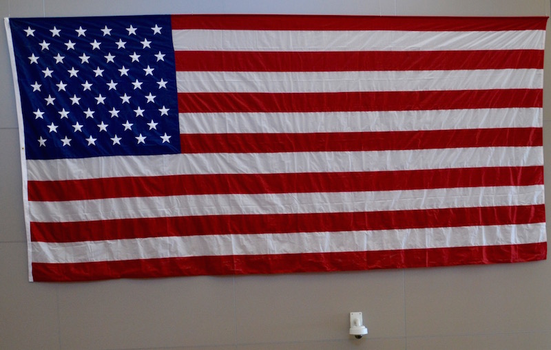 Le drapeau américain à l'arrivée aux Etats-Unis, ici à l'aéroport de Los Angeles :  treize bandes de couleurs représentant les 13 colonies britanniques sécessionnistes à l'origine de la création de l'État américain et autant d'étoiles que d'États fédérés © Archives Paris Tribune.